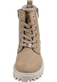 Bottine beige avec cuir texturé, semelle en caoutchouc épaisse, œillets en métal et laçage à l'avant. Fermeture éclair sur le côté pour un enfilage facile. Doublure douce visible.