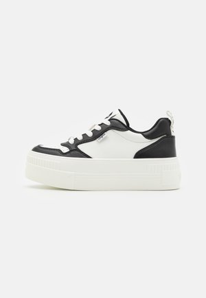 Zwart-witte sneakers met een gestructureerde rubberen zool, een glad leren bovenwerk, ronde neus en een trekhaak aan de hiel voor gemakkelijk aan- en uittrekken.