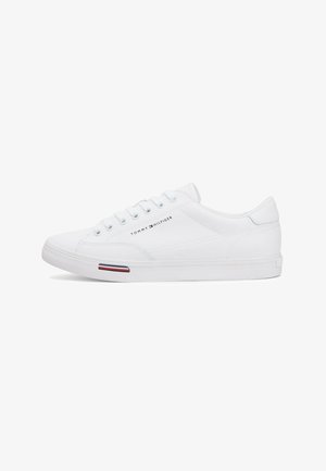 Witte lage sneaker met vetersluiting, Tommy Hilfiger-logo aan de zijkant en een klein rood-wit-blauw streepdetail op de zool.