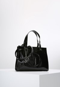Svart lackläder tote-väska med två handtag, med en upphöjd logotypdesign och en nyckelring som accent. Glänsande finish och strukturerad form.