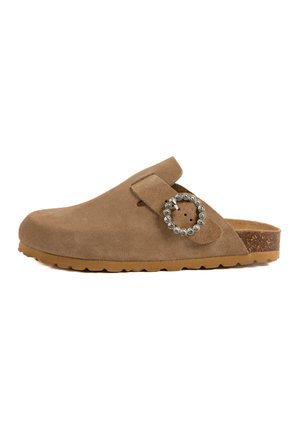 Sabot en daim marron avec un bout arrondi, accent en cristal circulaire sur la sangle et semelle en caoutchouc texturé. Décontracté et facile à enfiler.