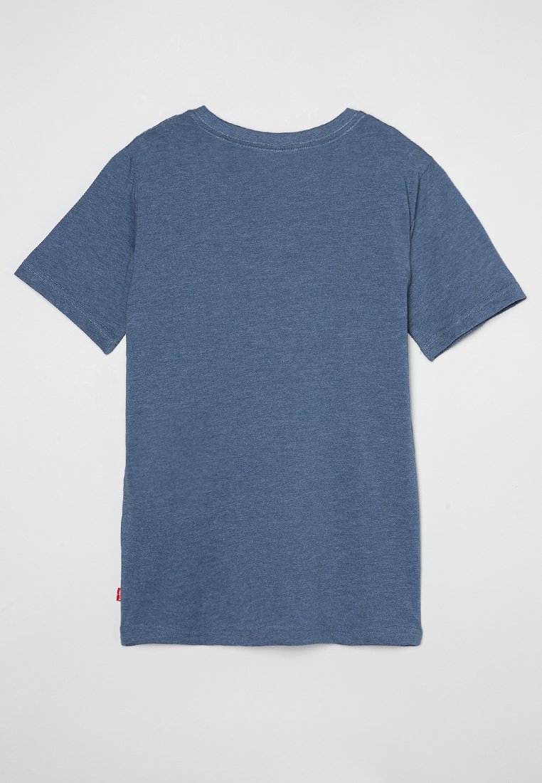 Camiseta de algodón azul, de mangas cortas, cuello redondo, diseño liso, con una pequeña etiqueta roja en la parte inferior izquierda. Textura suave, ajuste casual.