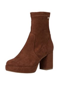 Bottines en suede marron avec un talon épais, un bout arrondi et des détails cousus. Présentent une texture lisse et un design à panneaux latéraux.