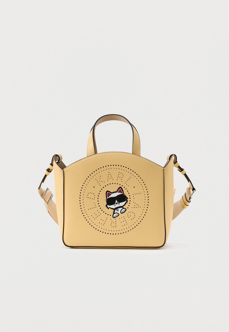 Κίτρινη τσάντα χειρός με κοντές λαβές και ρυθμιζόμενο ιμάντα, με κυκλικό διάτρητο λογότυπο και γραφικό γάτας που φορά γυαλιά ηλίου.