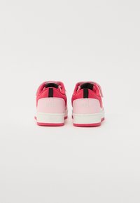 Baskets roses avec une bande velcro, dotées d'un dessus en cuir, d'une surface lisse, d'accents rose clair contrastants et d'une semelle en caoutchouc blanche.