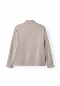 Jachetă bej deschis cu guler înalt și mâneci lungi. Textură netedă și design minimalist, cu croială dreaptă în talie.