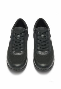 Scarpe da ginnastica nere con tomaia in rete e dettagli in sintetico lisci, dotate di lacci rotondi e suola in gomma testurizzata. Logo iconico sul lato.