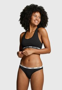 Schwarzer Sport-BH und passender Slip, beide aus Baumwolle. Verfügt über ein weißes Puma-Logoband. Das Design ist schlicht und figurnah.