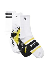 Tres pares de calcetines: uno con un estampado gráfico negro y amarillo, uno blanco con rayas negras y uno completamente blanco con logo.