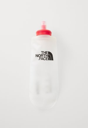 Bouteille d'eau flexible blanche avec un capuchon rouge et une buse ; présente le logo noir de The North Face sur le côté. Texture mate lisse.