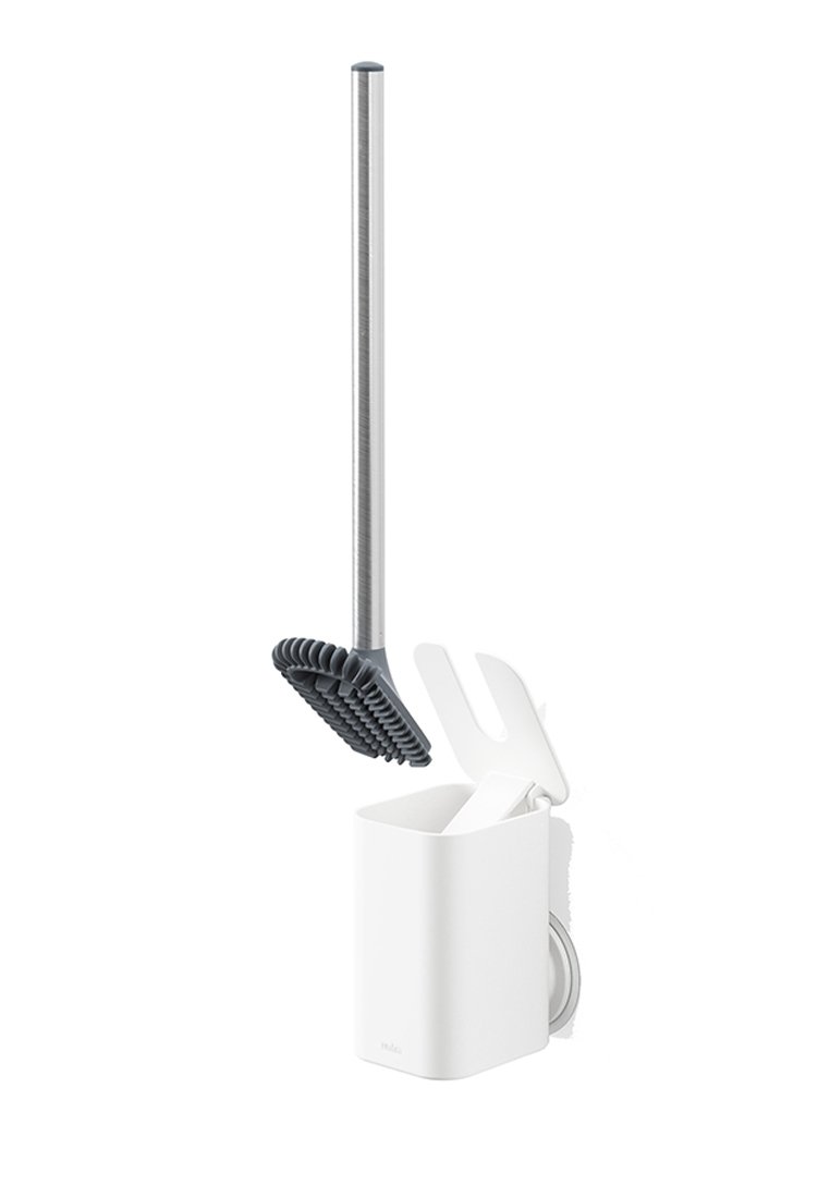 Brosse de toilette avec une tête en silicone grise et un manche en acier inoxydable, rangée dans un support blanc avec un couvercle hinged et un outil de nettoyage intégré.