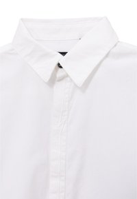 Camisa blanca de cuello con botón en la parte delantera y un cuello clásico en punta, mostrada en primer plano sobre un fondo blanco.