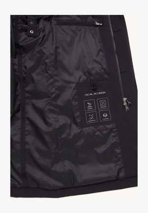 Schwarzes Jackeninnere mit matter Textur; ausgestattet mit wasserdichten und winddichten Etiketten sowie einem 4-Wege-Stretch-Detail. Mit Reißverschluss und Druckknopfverschlüssen.