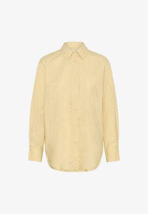 Majica z dolgimi rokavi svetlo rumene barve, z gumbi in ovratnikom s koničastimi robovi ter zapenjanjem na gumbe na manšetah, prikazana na belem ozadju.