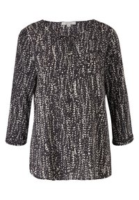Blouse noire avec motif de points blancs dispersés, manches trois-quarts et petit nœud noué au col rond.