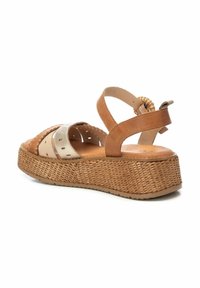 Sandalias de cuero marrón y beige con plataforma trenzada. Incluyen un diseño con recortes y una correa en el tobillo trasera con detalle trenzado.