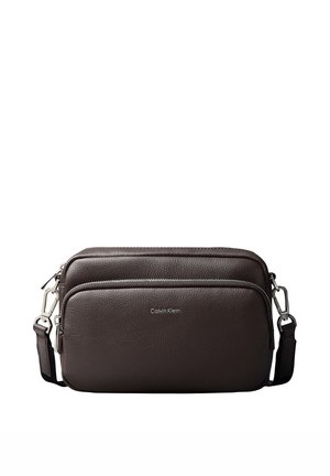 Dunkelbraune Calvin Klein Leder-Umhängetasche mit zwei Reißverschlussfächern und verstellbarem Riemen mit Metallverschlüssen.