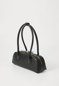 Schwarze Lederhandtasche mit zwei geschwungenen Griffen, goldfarbener Reißverschluss und abgerundetem Boden. Glatte Textur mit minimaler Ausstattung.