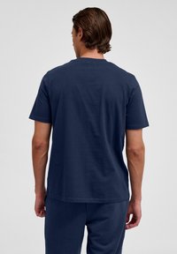 Marinfärgad t-shirt med kort ärm gjord av mjuk bomull, med rund halsringning och en avslappnad passform. Baksidan har en slät yta.