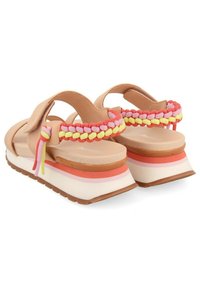 Sandalias tostadas con tiras trenzadas multicolores, plataforma gruesa con rayas rosas y naranjas, y suela texturizada para tracción.