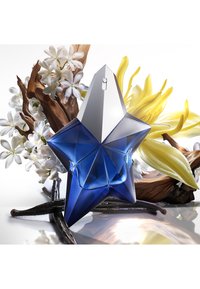 Blå stjerneformet parfume flaske med en sølvfarvet hætte, omgivet af hvide blomster, vaniljestænger og gule kronblade på en reflekterende overflade.