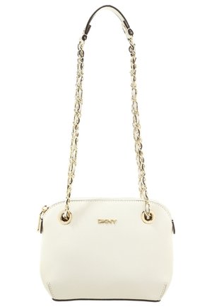 Kleine weiße Handtasche mit goldener Kettenriemen, DKNY-Logo, abgerundeten Kanten und Reißverschluss oben.