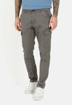 Graue Cargo-Hosen mit mehreren Seitentaschen, einem Knopfverschluss und einem taillierten Beinanschnitt, kombiniert mit weißen Sneakern.