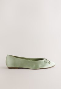 Ballerine vert clair avec bout arrondi, petit nœud et subtils accents de perles et perles métalliques sur un fond neutre.