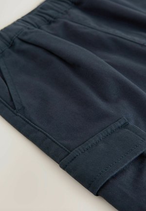 Dunkelblaue Stoffshorts mit einem elastischen Bund, umgeschlagenem Saum und Flachnaht für Langlebigkeit. Glatte, leichte Textur.