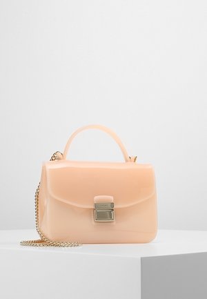 Lille blank ferskenfarvet håndtaske med topgreb, lås i guldton og aftagelig guldkæde som rem på hvid overflade.