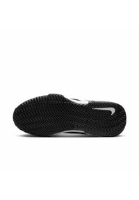 Mustal spordijalanõu tald, millel on siksakiline mustrimuster, ümar varvas ja valge Nike logo kandetoel. Sile tekstuur ja vastupidav disain.