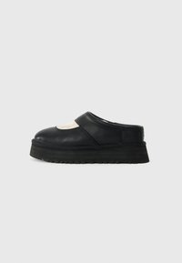 Sorte læder slip-on klipklapper med en hævet gummisål og en glat overflade. Har en afrundet tå og et udskæringselement på overdelen.