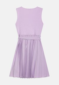 Bezramionowa, lawendowa sukienka z prążkowanym plecakiem, plisowaną spódnicą i pasującym materiałowym paskiem zawiązanym w talii, pokazana z tyłu na białym tle.