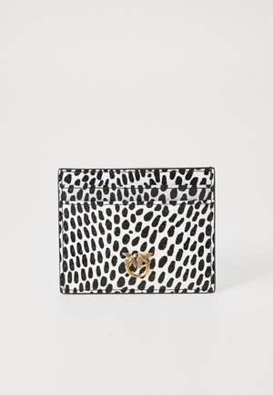 Porte-cartes en noir et blanc, avec un motif à pois, surface lisse et un emblème en forme d'abeille dorée. Forme rectangulaire compacte avec plusieurs fentes.