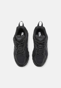Black athletic shoes featuring a mesh upper, rubber sole, and textured accents. Includes laces and two pull tabs on the heels.