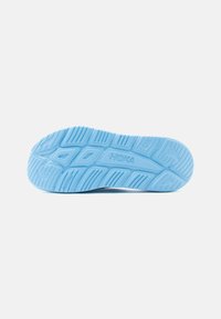 Σόλα αθλητικού παπουτσιού ανοιχτού γαλάζιου χρώματος με βαθιές αυλακώσεις και το λογότυπο «HOKA» στο κέντρο, πάνω σε απλό λευκό φόντο.