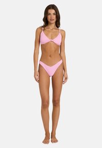 Rožnata rebrasta bikini komplet, ki vključuje trikotno zgornjega dela z detajlom pentlje spredaj in nizkokakovostnim dnom. Gladka tekstura in prilegajoča se zasnova.