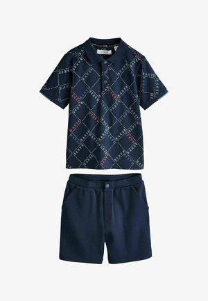 Tumši zila īsroku polo ar dimanta rakstu un daudzkrāsainu tekstu; saskaņotas tumši zilas šortas ar kabatām un pogas aizdari. Mīksts kokvilnas maisījums.