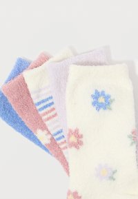 Πέντε ζευγάρια αφράτων κάλτσων σε παστέλ χρώματα: λευκές με λουλούδια, λεβάντα, λευκές με ρίγες, ροζ με λουλούδια και μονόχρωμες μπλε.