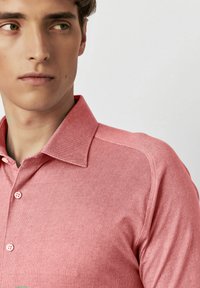 Korte mouwen, roze button-up shirt gemaakt van textuurstof. Kenmerkt zich door een klassiek kraag en subtiele stikdetails langs de schouders.