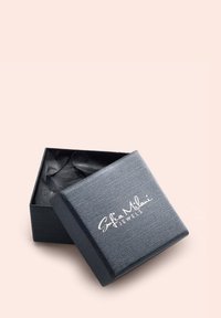 Svart, texturerad smyckesask med ett lock som är något öppet och avslöjar svart silkespapper inuti. På locket finns varumärkesnamnet i vit kursiv stil.