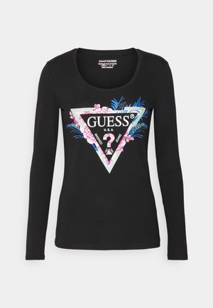 Camisa negra de manga larga con diseño floral y un gran logo triangular de Guess en blanco, rosa y azul en el centro delantero.