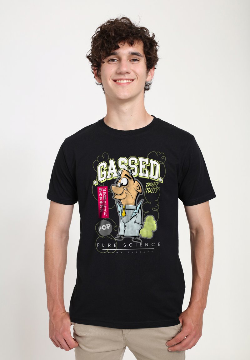 Camiseta de algodón negra con un personaje de dibujos animados en traje, con el texto "GASSED" y detalles en verde, sobre un fondo liso.