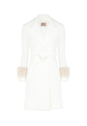 Manteau en laine blanche avec une taille cintrée, de larges revers et des accents en fausse fourrure sur les manches. Comprend des poches latérales et un détail en nœud à l'avant.