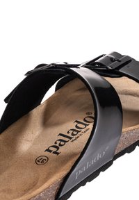 Sandalo a scivolo in pelle patinata nera con un'ampia fascia, soletta in sughero e suola in gomma. Marchio stampato sulla soletta.