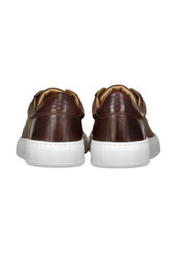 Sneaker in pelle marrone con suole in gomma bianca, design arrotondato, texture liscia e dettagli di cucitura minimalista sul retro.