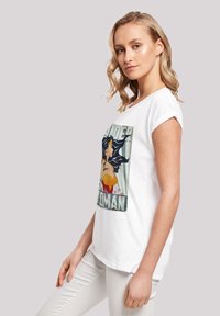 Valge puuvillane T-särk, millel on värvikas Wonder Woman graafika. Lühikesed varrukad, ümar kaelus, lahtine sobivus ja sile tekstuur.
