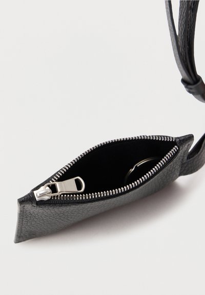 Μαύρο πορτοφόλι χειρός από υφή δέρματος με ασημί φερμουάρ, μερικώς ανοιχτό σε λευκό φόντο.