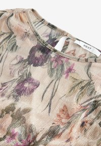 Przezroczysty materiał w kwiatowy wzór w delikatnym beżu z fioletowymi i zielonymi akcentami. Posiada okrągły dekolt i subtelny połysk. Widoczna metka marki.