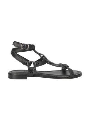 Black leather sandals feature a flat sole, multiple straps, hardware accents, and an ankle buckle for adjustable fit.
